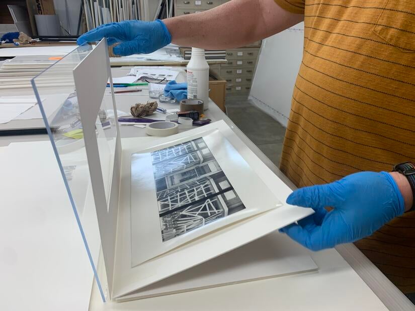 Steve Beswick, museum preparator, frames "Decoration for Hurricane Gloria, 1985" by Kenji Nakahashi, on March 7, 2023 at UCR ARTS. (UCR/Sandra Baltazar Martínez)